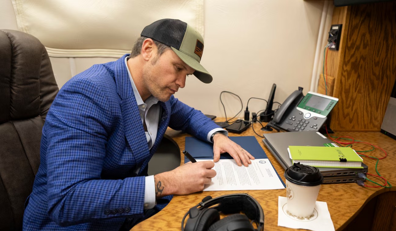 Secretary of Defense Pete Hegseth signing a document